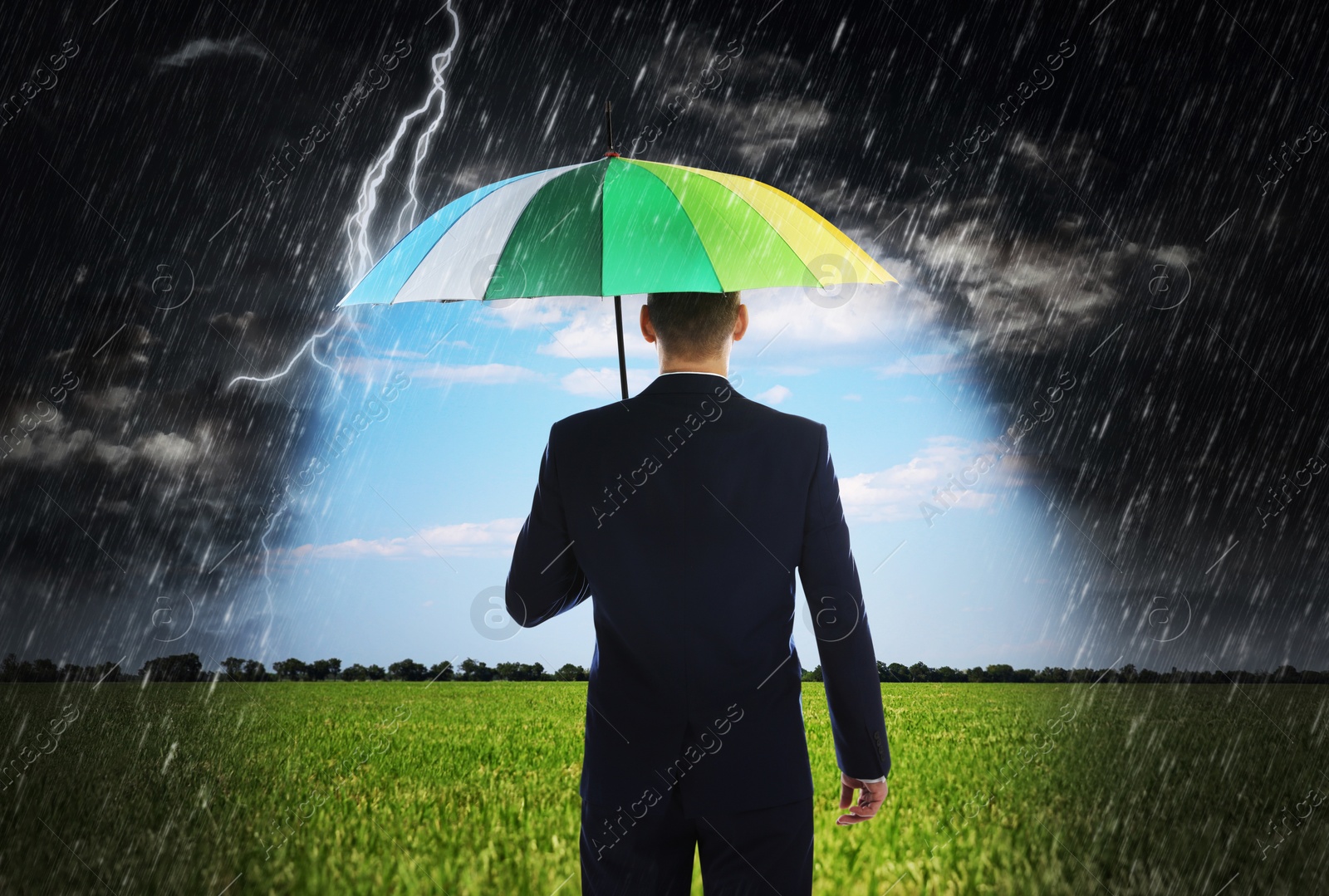 Image of Businessman with umbrella under heavy rain. Insurance concept