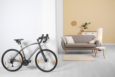 Photo of Modern apartment interior with bicycle near wall. Space for text