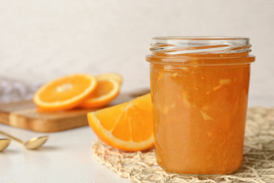 Homemade delicious orange jam on light table. Space for text