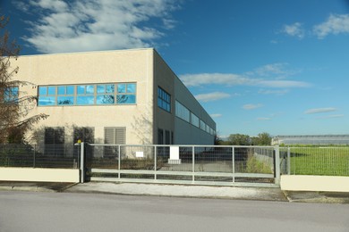 Photo of Factory building surrounded by fence on sunny day