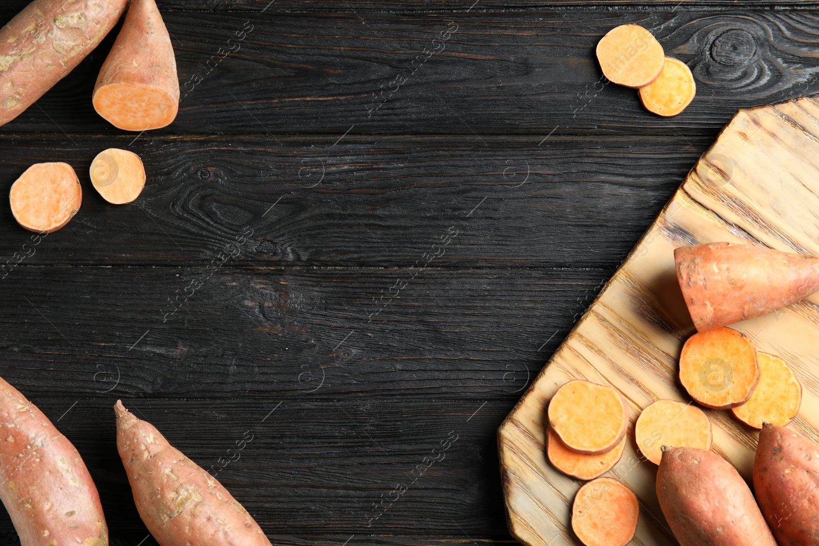 Photo of Flat lay composition with sweet potatoes and space for text on wooden background