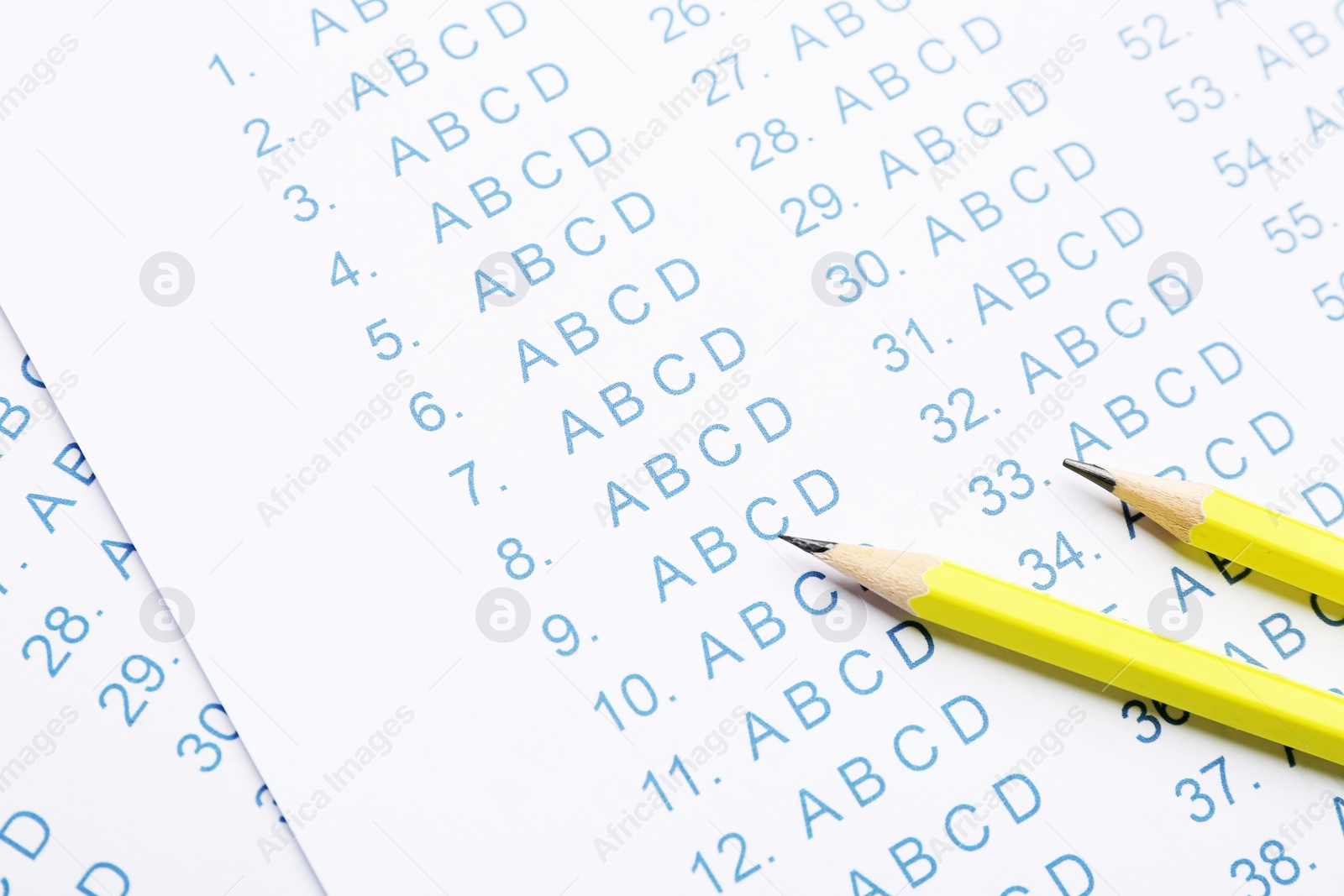 Photo of Yellow pencils on answer sheets, closeup view