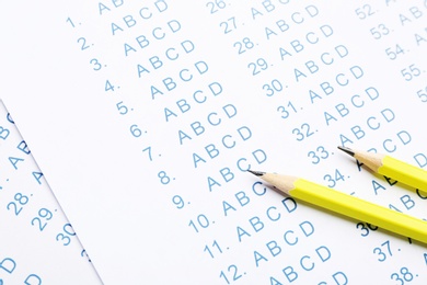 Yellow pencils on answer sheets, closeup view