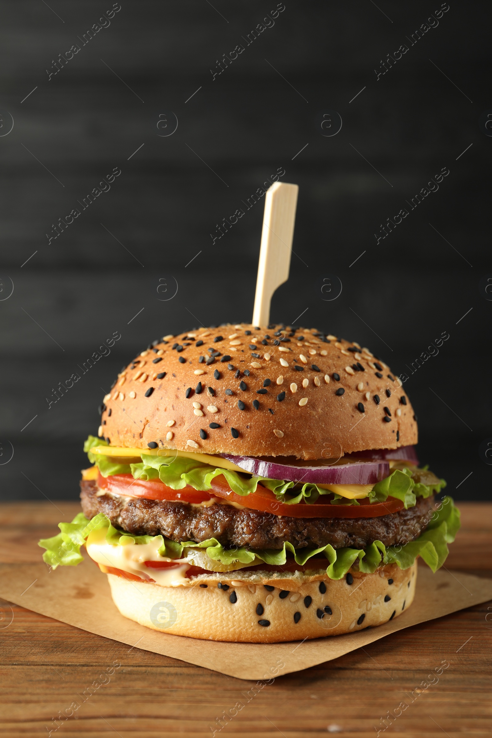 Burger with delicious patty on wooden table Photo of Burger with delicious patty on wooden table