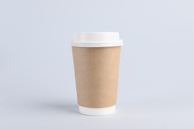 Photo of Paper cup with plastic lid on light background. Coffee to go