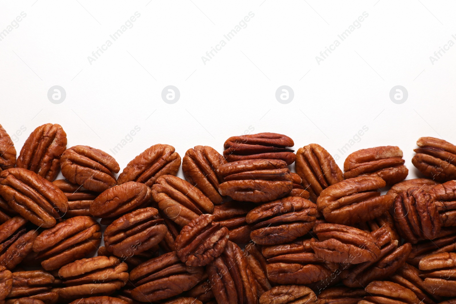 Photo of Delicious fresh pecan nuts on white background, flat lay. Space for text