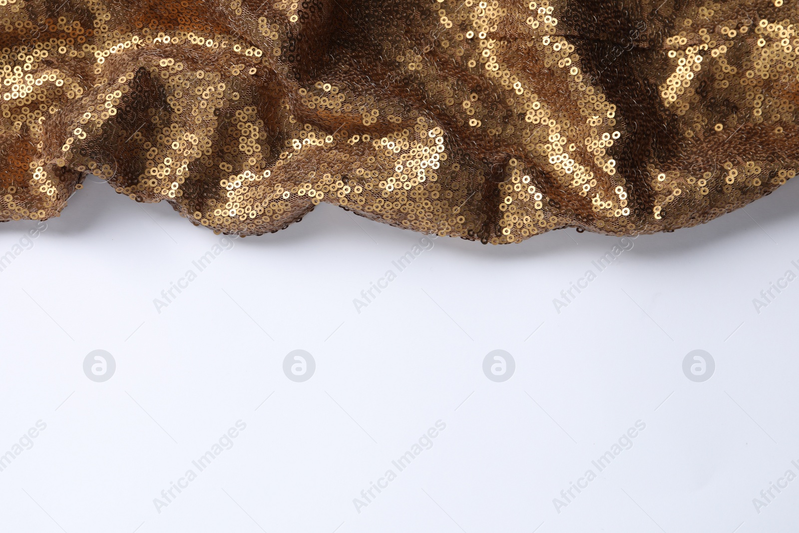 Photo of Golden shiny sequin fabric on white background. Space for text