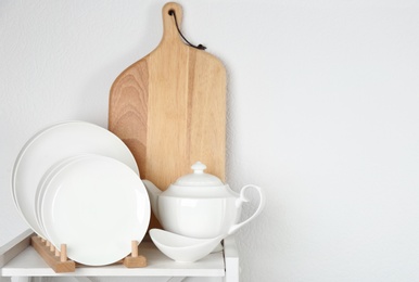 Different clean tableware on shelf in kitchen