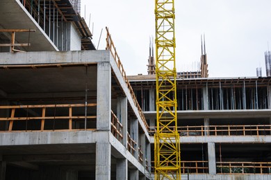 Photo of Construction site with tower crane near unfinished building