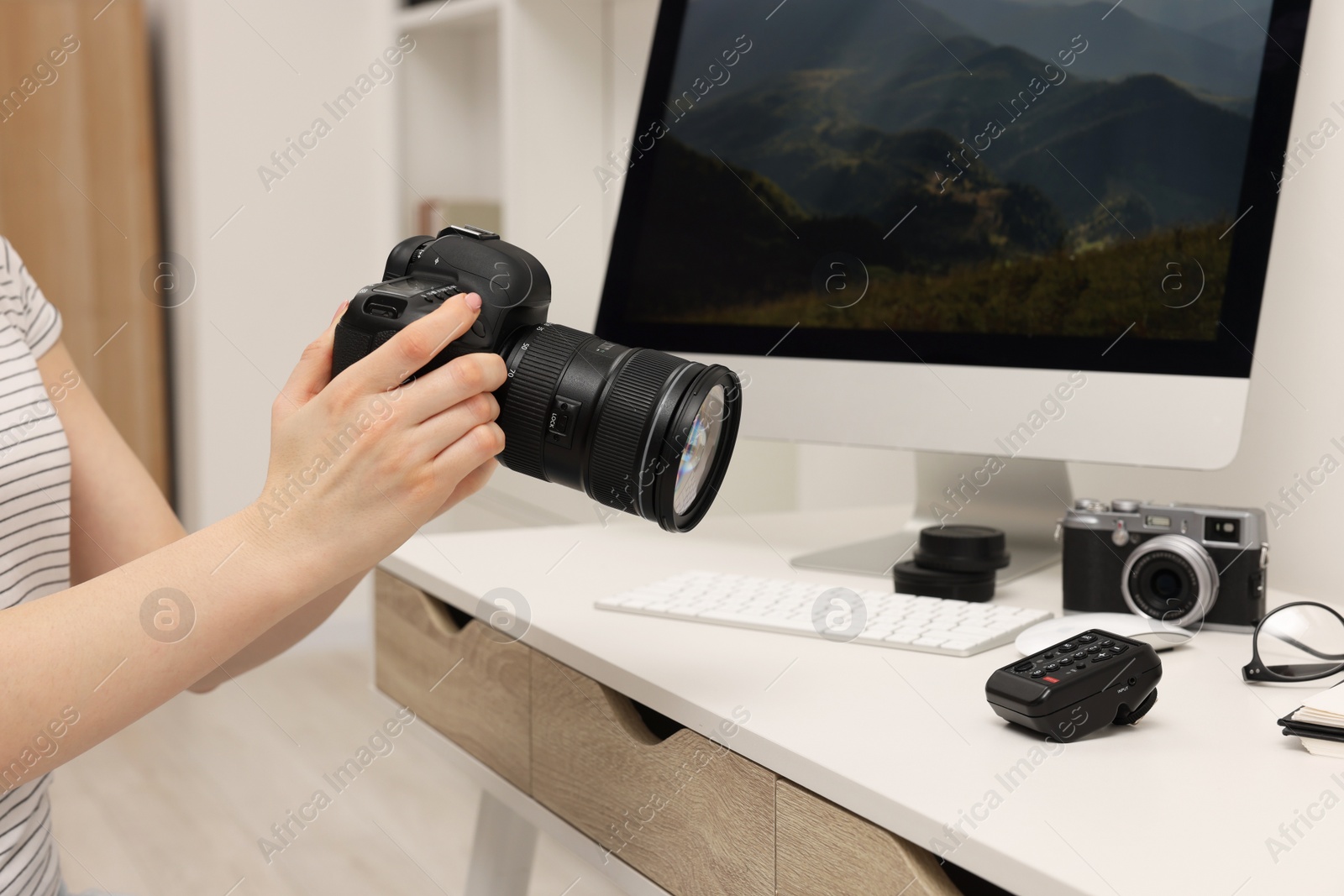 Photo of Photographer with camera at white table indoors, closeup