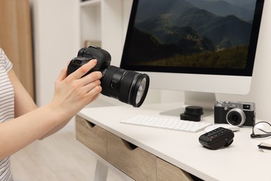 Photographer with camera at white table indoors, closeup