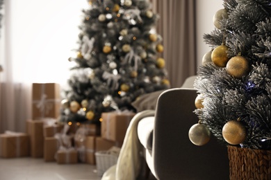 Photo of Beautiful Christmas tree decorated with balls in stylish room interior