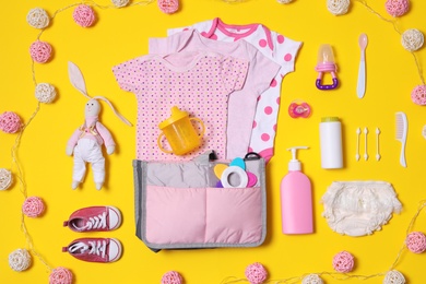 Flat lay composition with baby accessories and maternity bag on color background