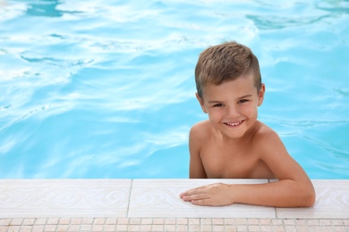 Photo of Cute little boy in outdoor swimming pool