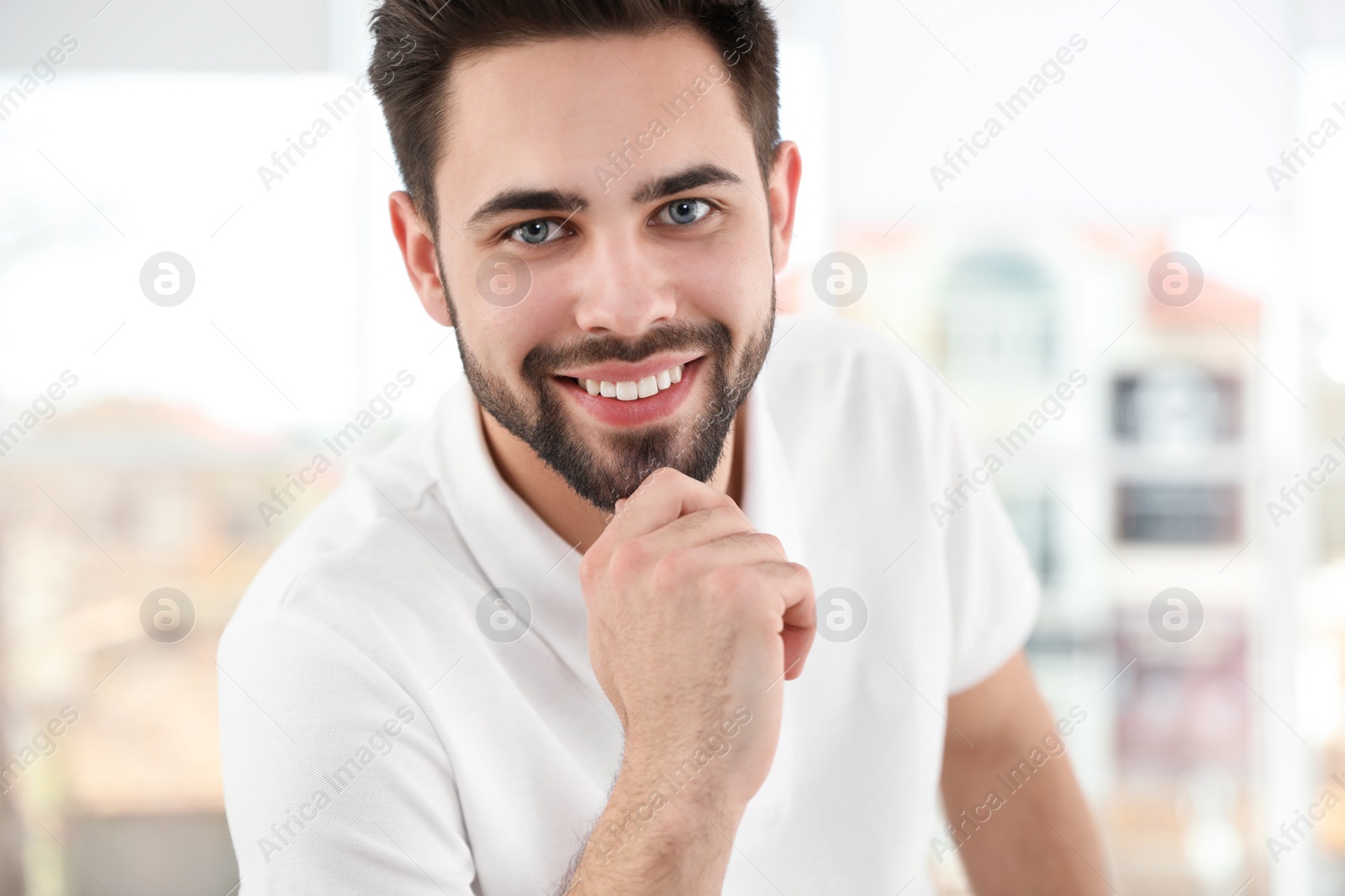 Photo of Portrait of handsome man smiling in light room, closeup