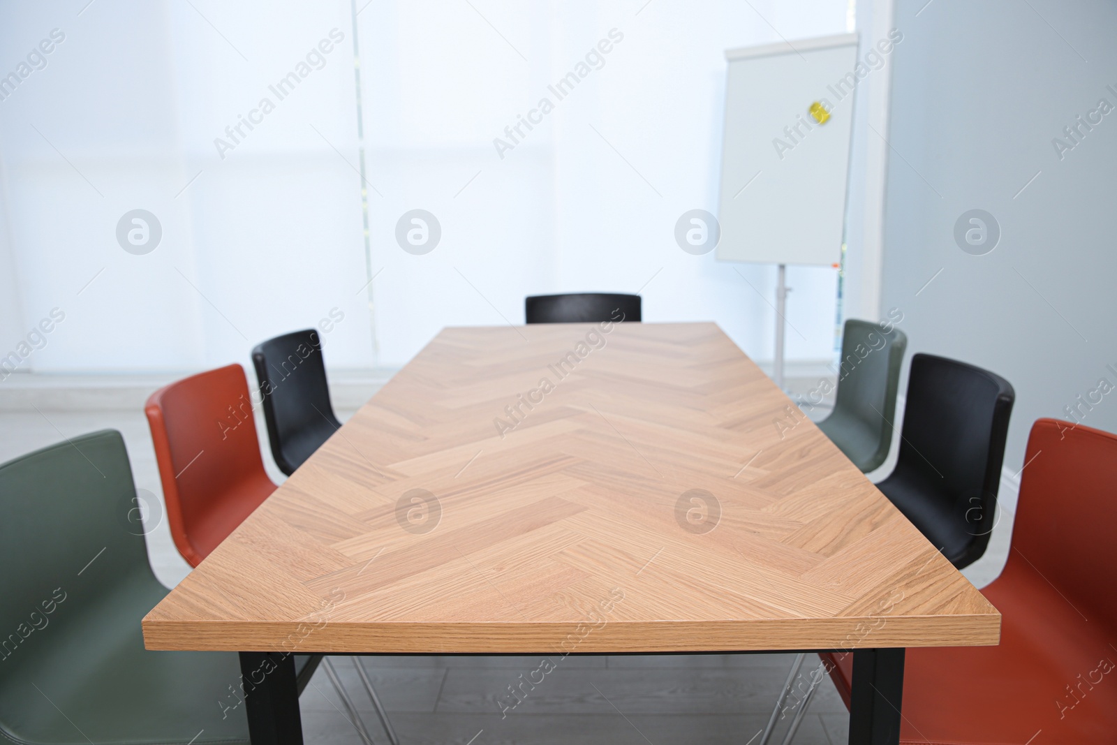 Photo of Conference room interior with wooden table and flipchart