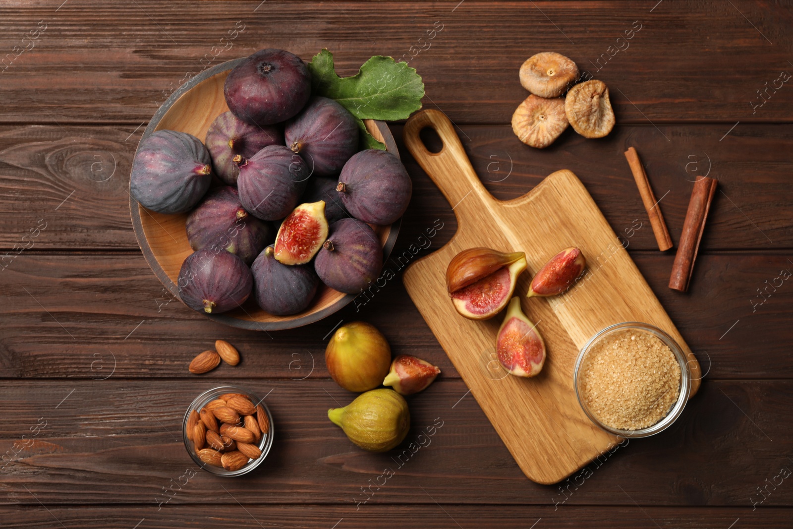 Photo of Flat lay composition with raw and dry figs on wooden table