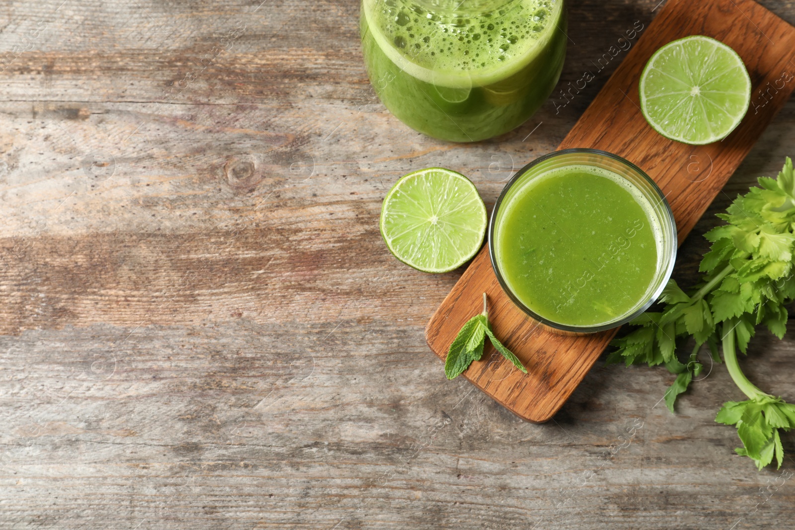 Photo of Glassware with delicious detox juice and ingredients on wooden background, top view