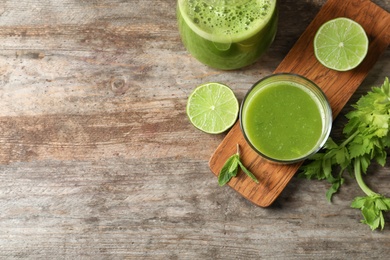 Photo of Glassware with delicious detox juice and ingredients on wooden background, top view