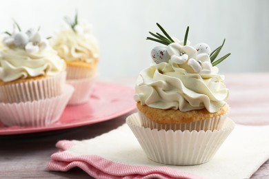 Tasty Easter cupcakes with vanilla cream on wooden table