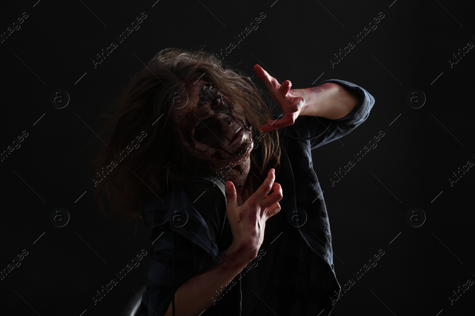 Photo of Scary zombie on dark background. Halloween monster