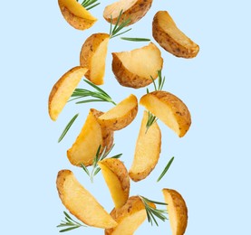 Tasty baked potatoes and rosemary falling on light blue background