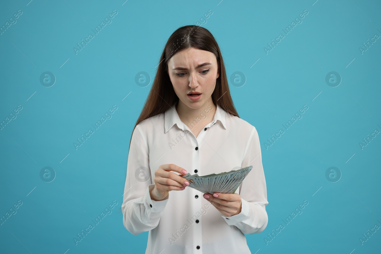 Photo of Woman with dollar banknotes on light blue background