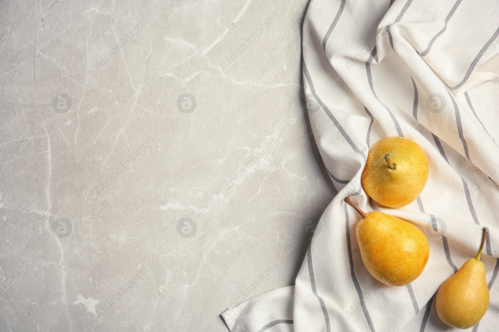 Photo of Ripe pears and striped fabric on grey background, top view. Space for text