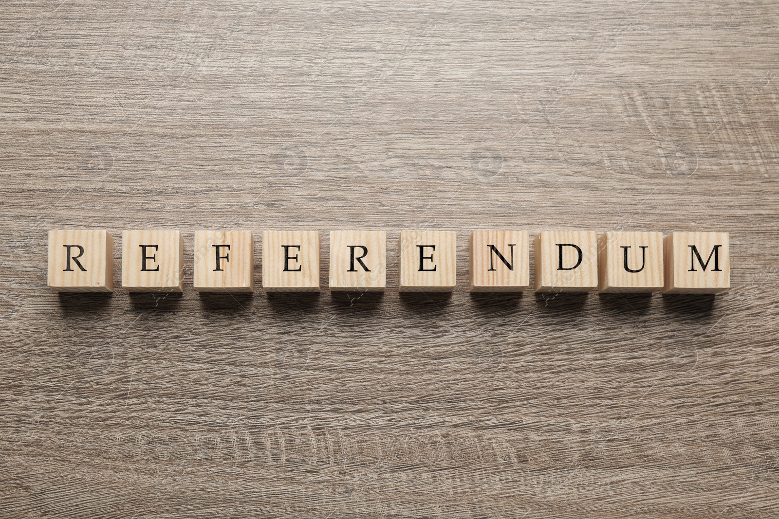 Photo of Word Referendum of cubes on wooden table, flat lay