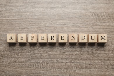 Photo of Word Referendum of cubes on wooden table, flat lay