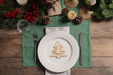 Festive place setting with beautiful dishware, cutlery and decor for Christmas dinner on wooden table, flat lay