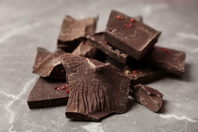 Pieces of delicious dark chocolate on table