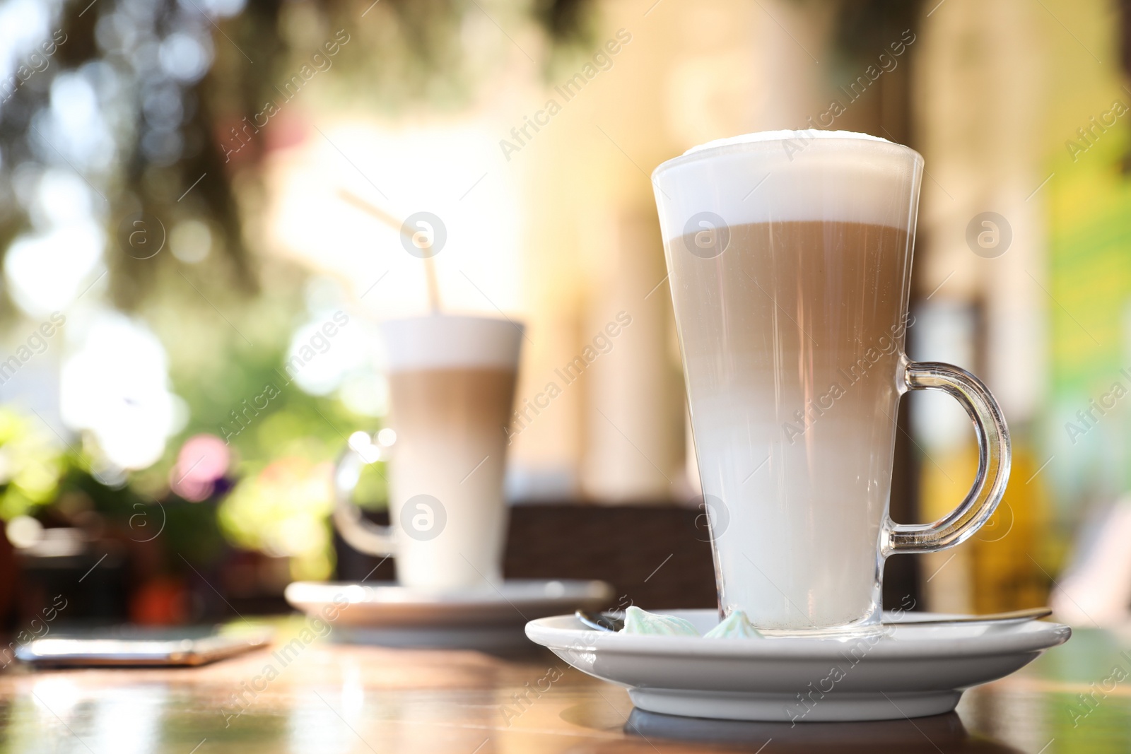 Photo of Glass cup of coffee on table in outdoor cafe, space for text