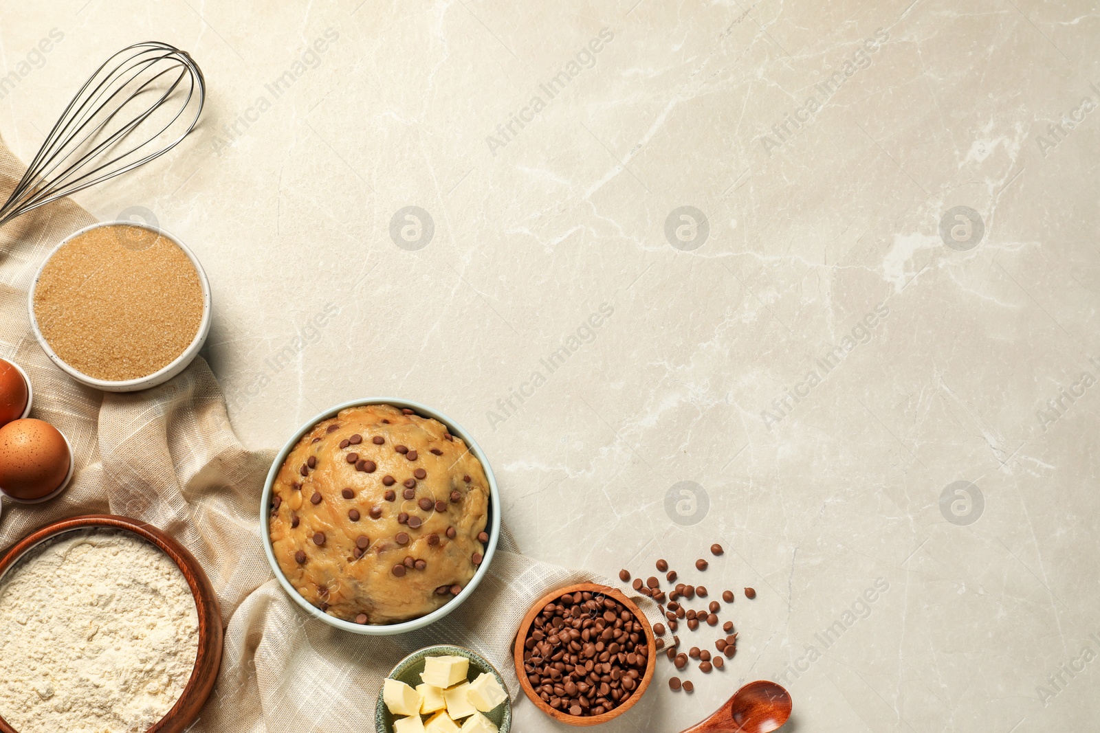 Photo of Dough and ingredients for cooking chocolate chip cookies on light grey table, flat lay. Space for text