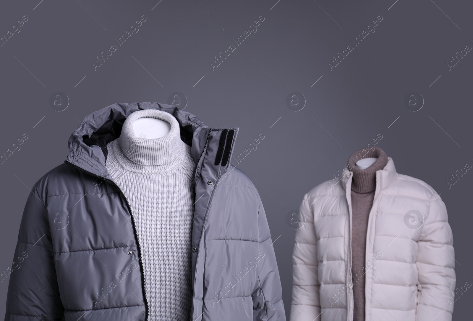 Photo of Male and female mannequins dressed in stylish outfits on grey background