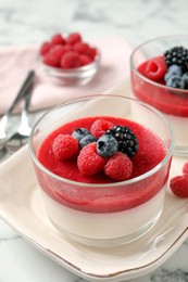 Photo of Delicious panna cotta with fruit coulis and fresh berries served on white marble table