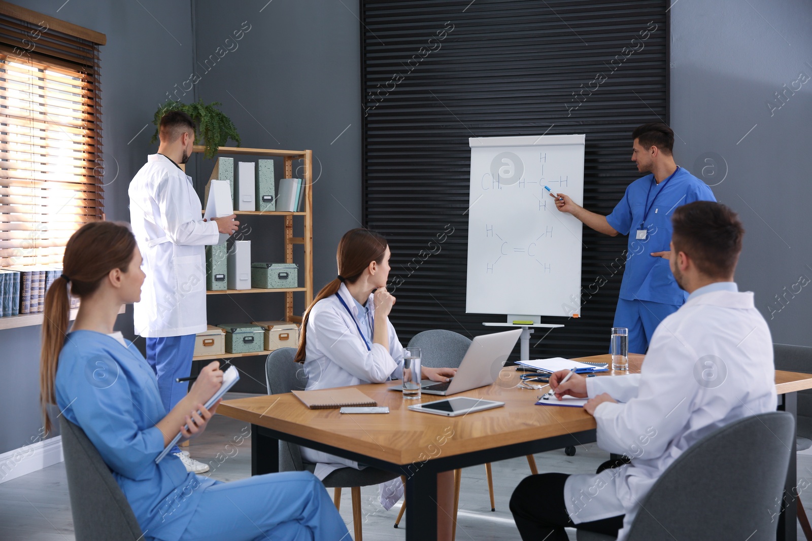 Photo of Team of professional doctors having meeting in office