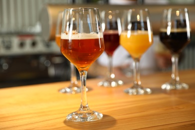 Different sorts of beer on wooden bar counter