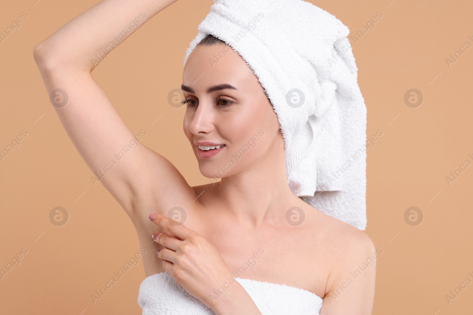 Photo of Beautiful woman showing armpit with smooth clean skin on beige background