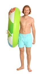 Photo of Attractive young man in swimwear with colorful inflatable ring on white background