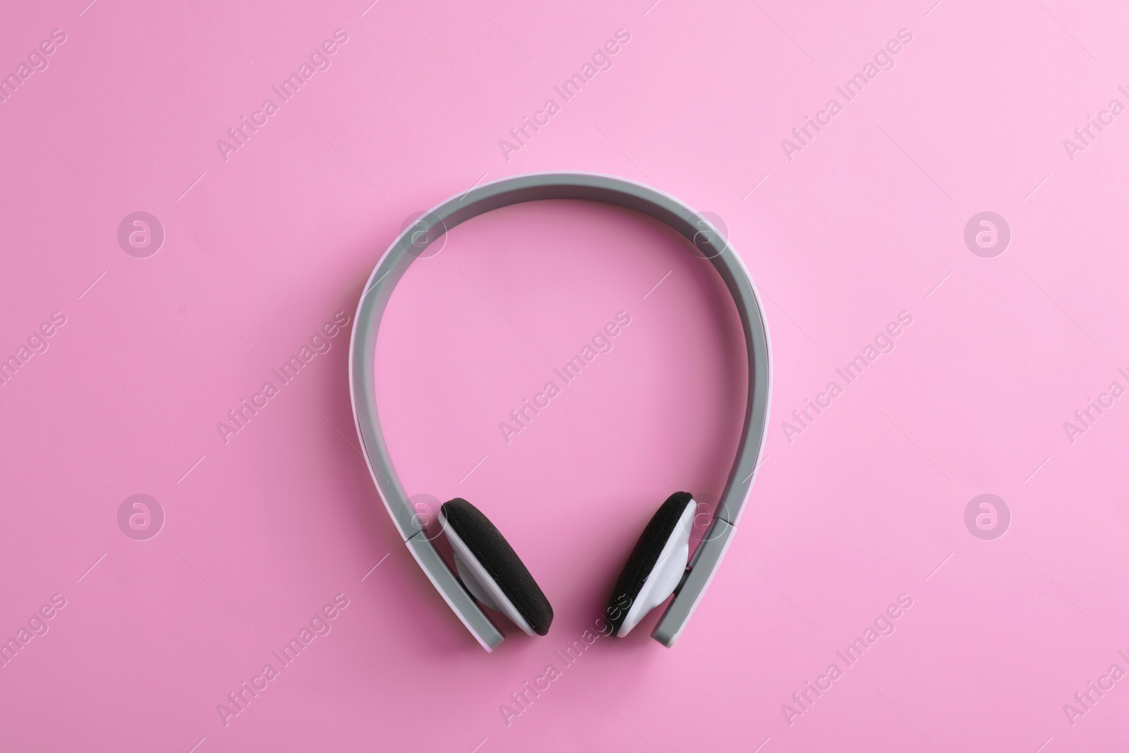 Photo of Wireless headphones on color background, top view