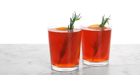 Photo of Aperol spritz cocktail, orange slices and rosemary in glasses on marble table against white background