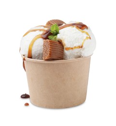 Photo of Scoops of tasty ice cream with mint leaves, caramel sauce and candies in paper cup isolated on white