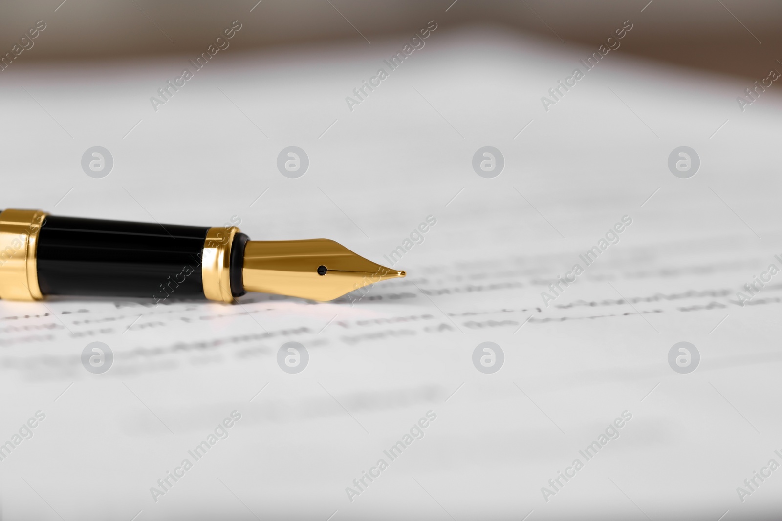 Photo of Fountain pen on document, closeup and space for text. Notary contract