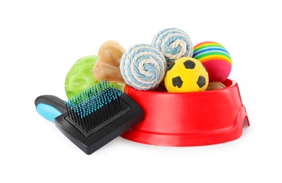 Photo of Pet toys, bowl and brush on white background