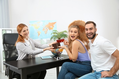 Beautiful young couple visiting travel agency office