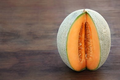 Photo of Cut delicious ripe melon on wooden table, space for text