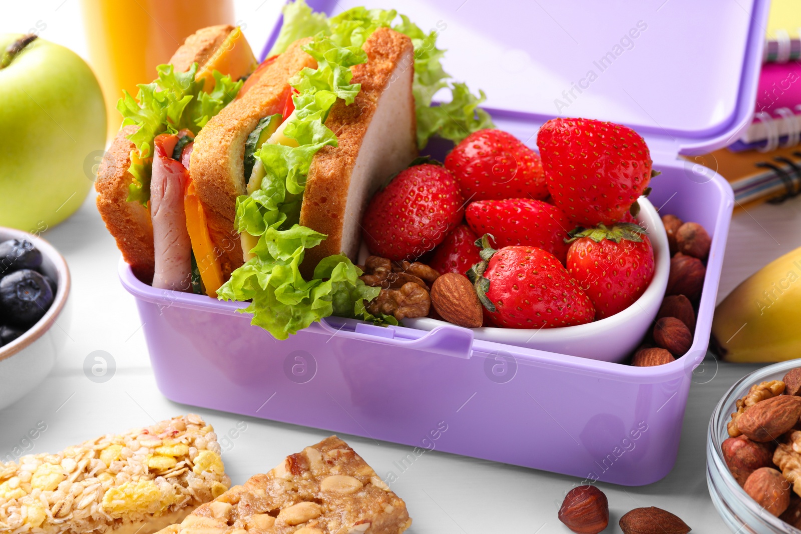 Photo of Lunch box with healthy food for schoolchild on white wooden table, closeup