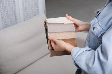 Photo of Woman choosing fabric among colorful samples at home, closeup. Space for text