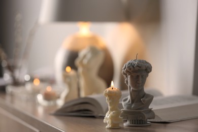 Photo of Beautiful David bust candles on table indoors